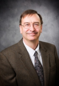 dr. weidlich wearing a brown suite and glasses