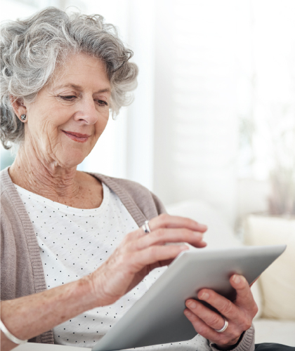 older woman reading on ipad