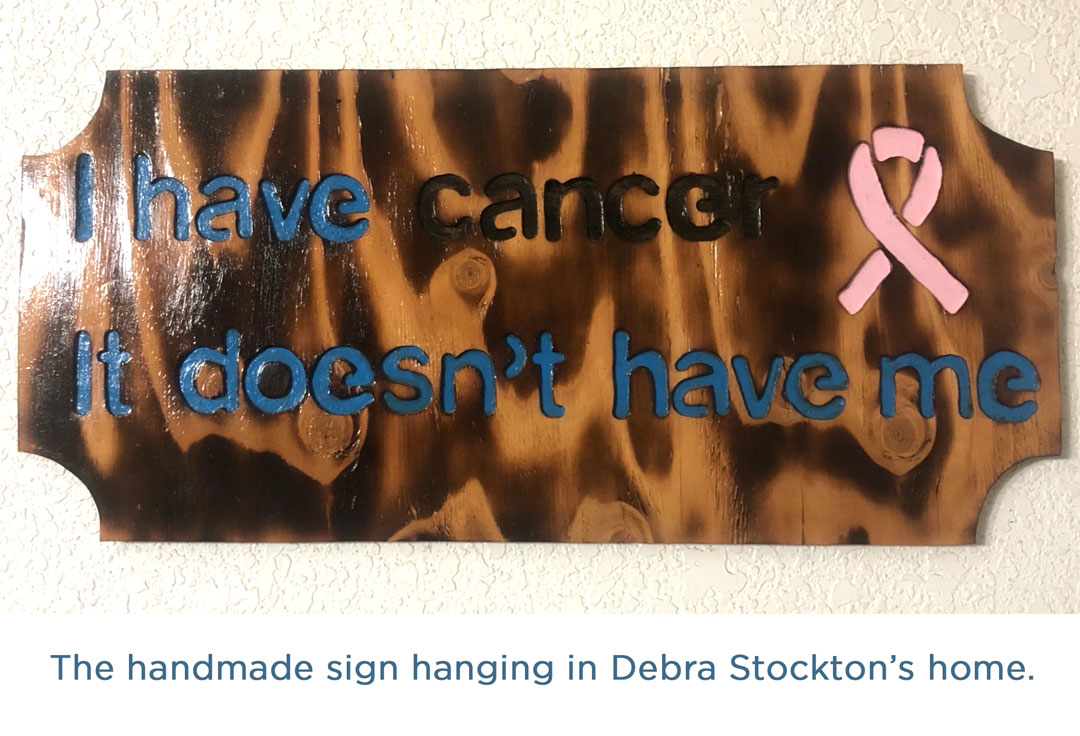 Wooden sign with the words, "I have cancer. It doesn't have me." written on it.