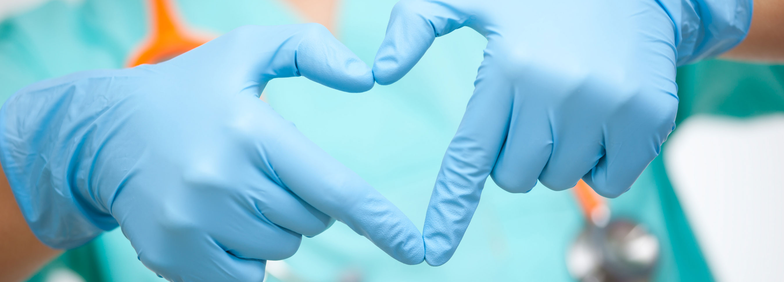 Image of hands in surgical gloves making the shape of a heart